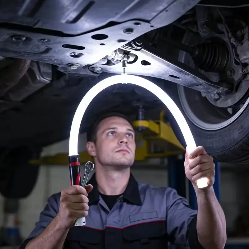 Mechanic holding the Nagslang Flex in an arch under a car on a hoist